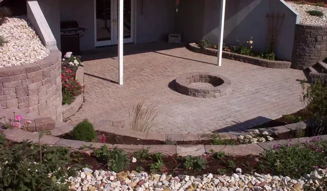A patio with a fire pit in the middle of it