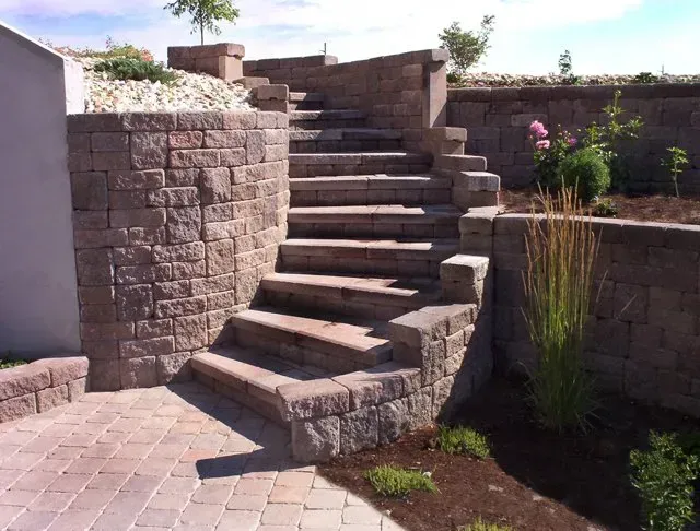 A set of stone stairs leading up to a brick wall