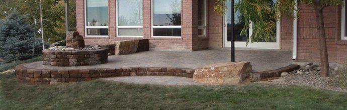 A brick house with a patio and a fountain in front of it.