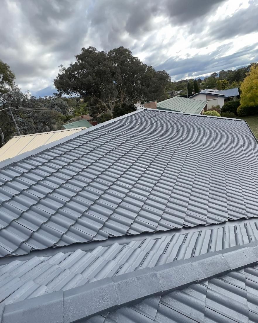 A Close Up Of A Roof With A Cloudy Sky In The Background — Blue Painting & Decorating In Taylor, ACT
