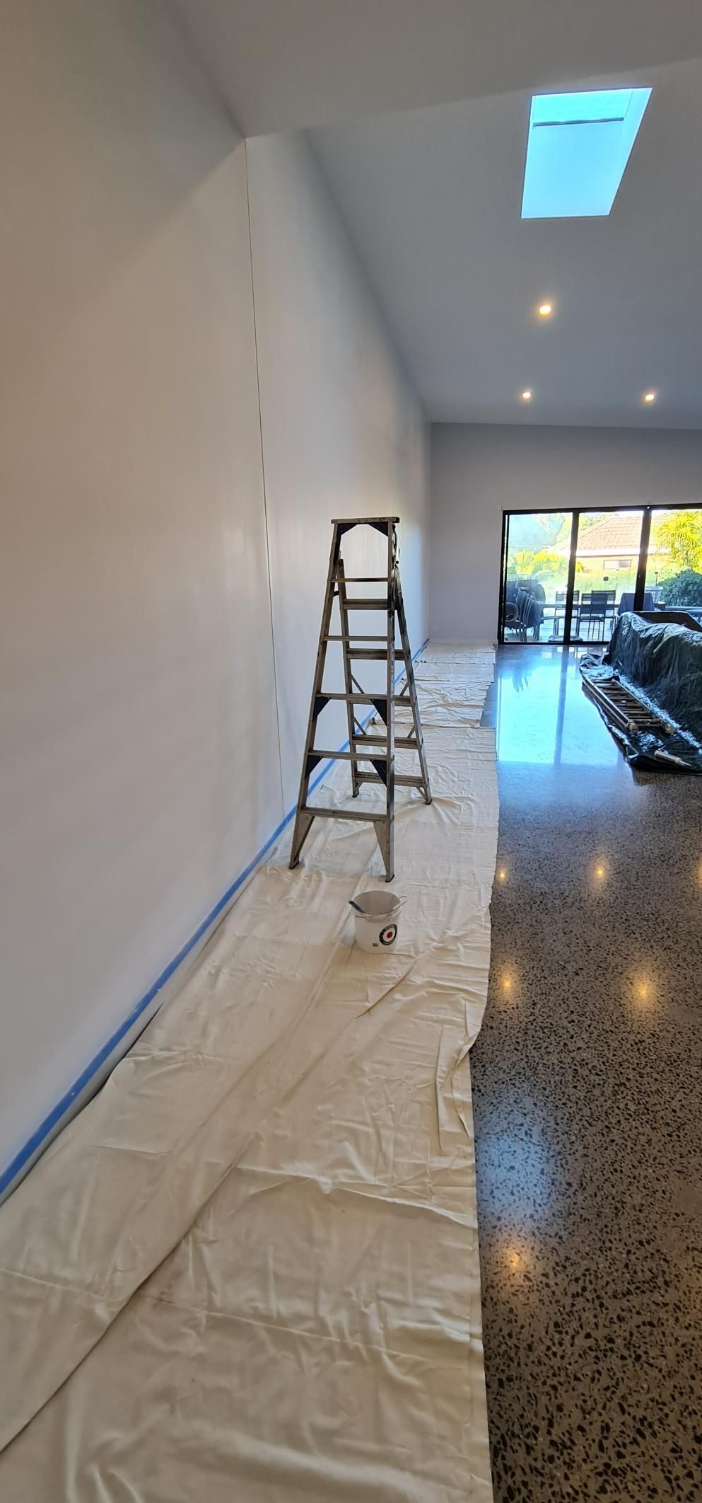 A Ladder Is Sitting On Top Of A White Tarp In A Room — Blue Painting & Decorating In Taylor, ACT