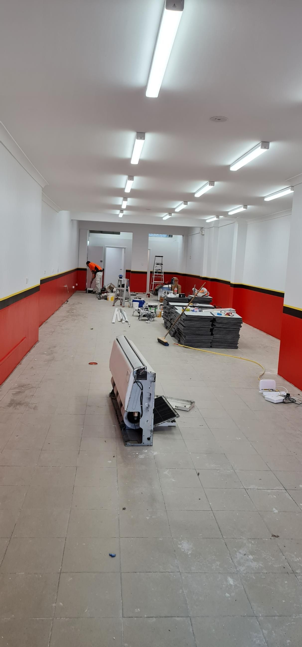 A Large Empty Room With Red Walls And White Walls — Blue Painting & Decorating In Taylor, ACT