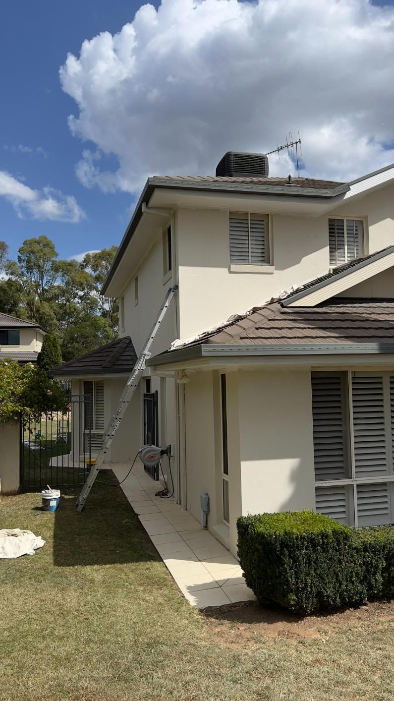 A House With A Ladder Attached To The Side Of It Is Being Painted — Blue Painting & Decorating In Taylor, ACT