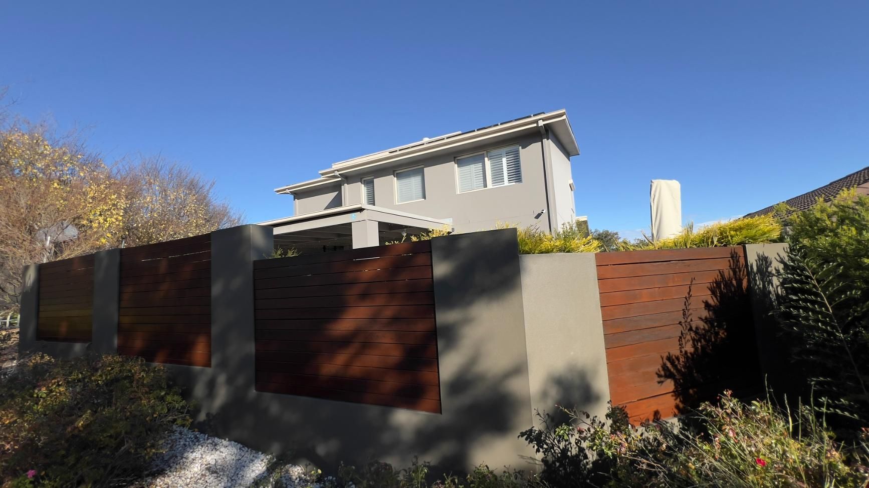 A House With A Fence Around It And A Blue Sky In The Background — Blue Painting & Decorating In Taylor, ACT