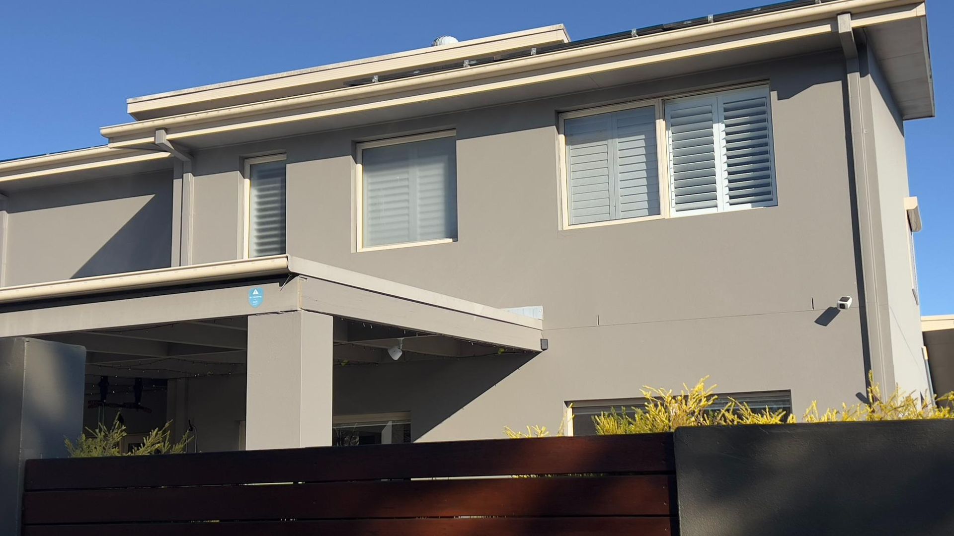 A House With A Lot Of Windows And A Fence In Front Of It — Blue Painting & Decorating In Taylor, ACT