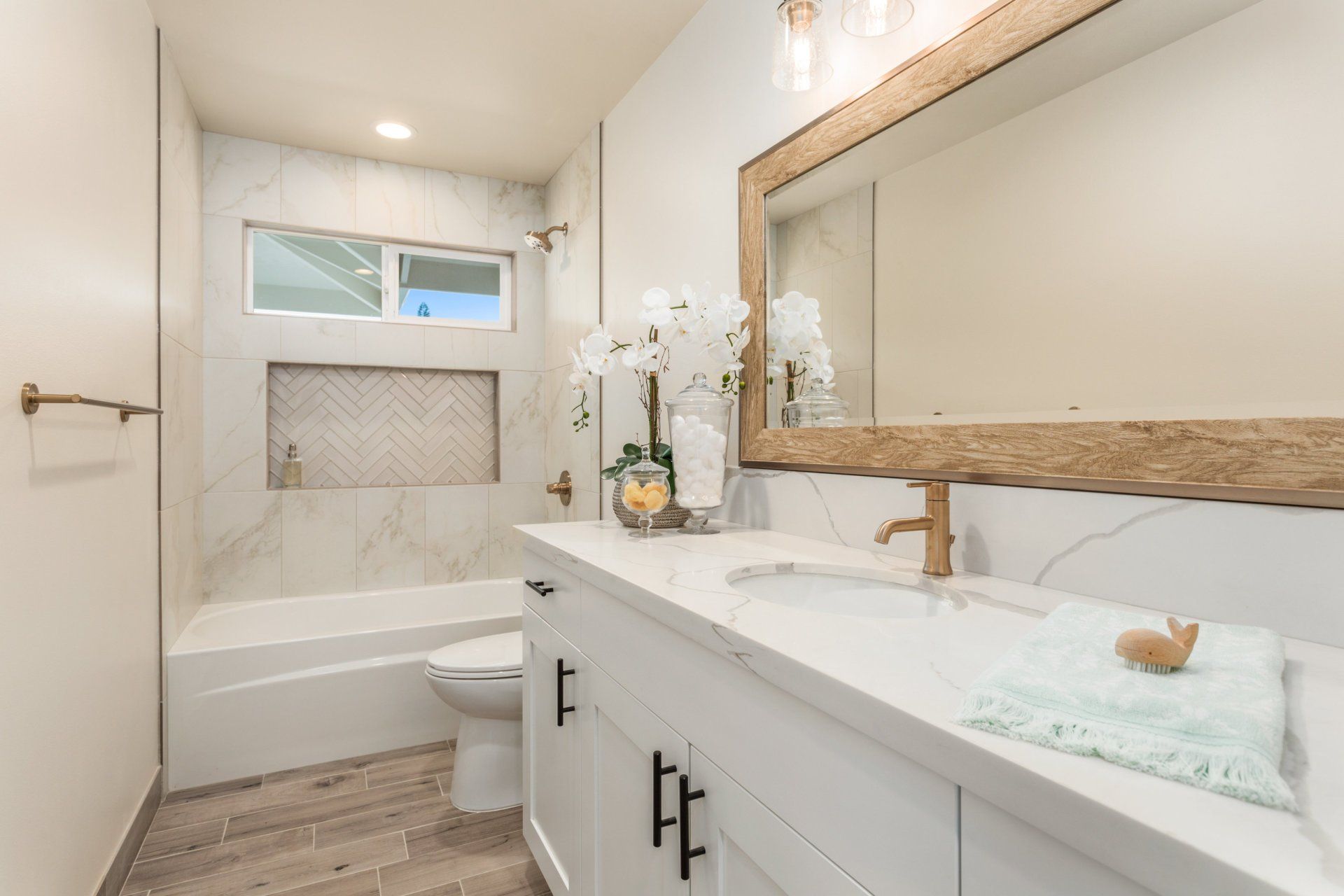 a bathroom with a sink , toilet , tiled tub and mirror.