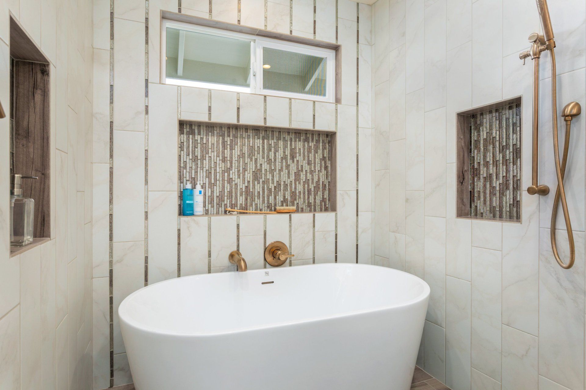 a bathroom with a tiled bathtub and a shower.