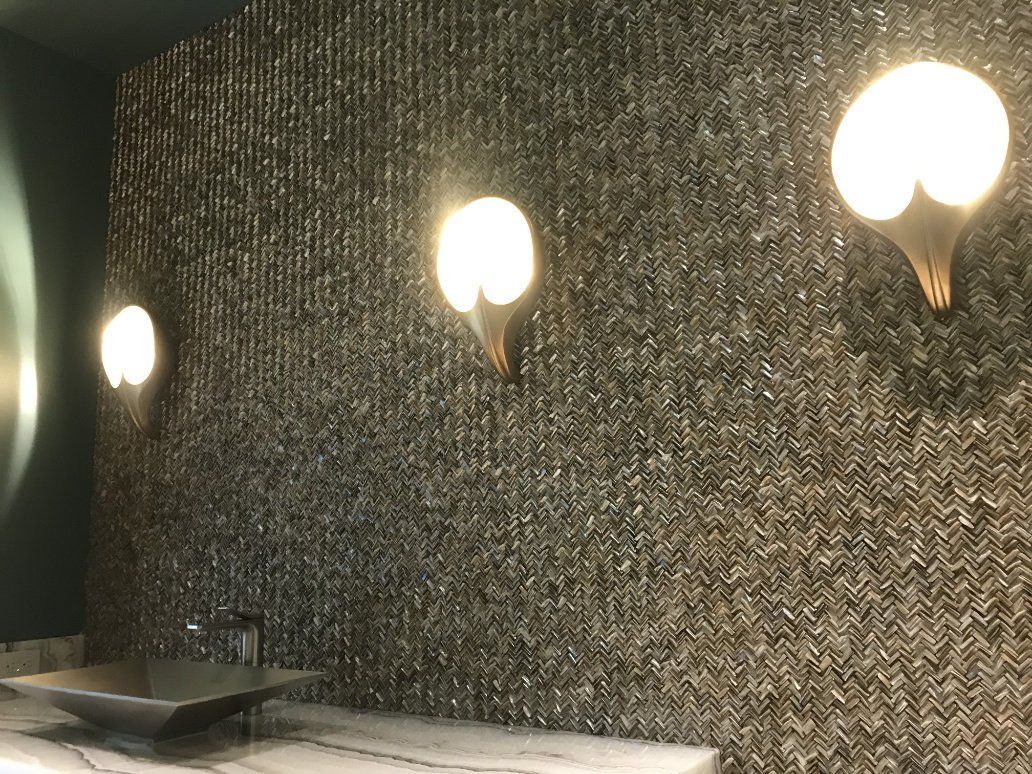 a bathroom with a sink and two lights on a tiled wall .