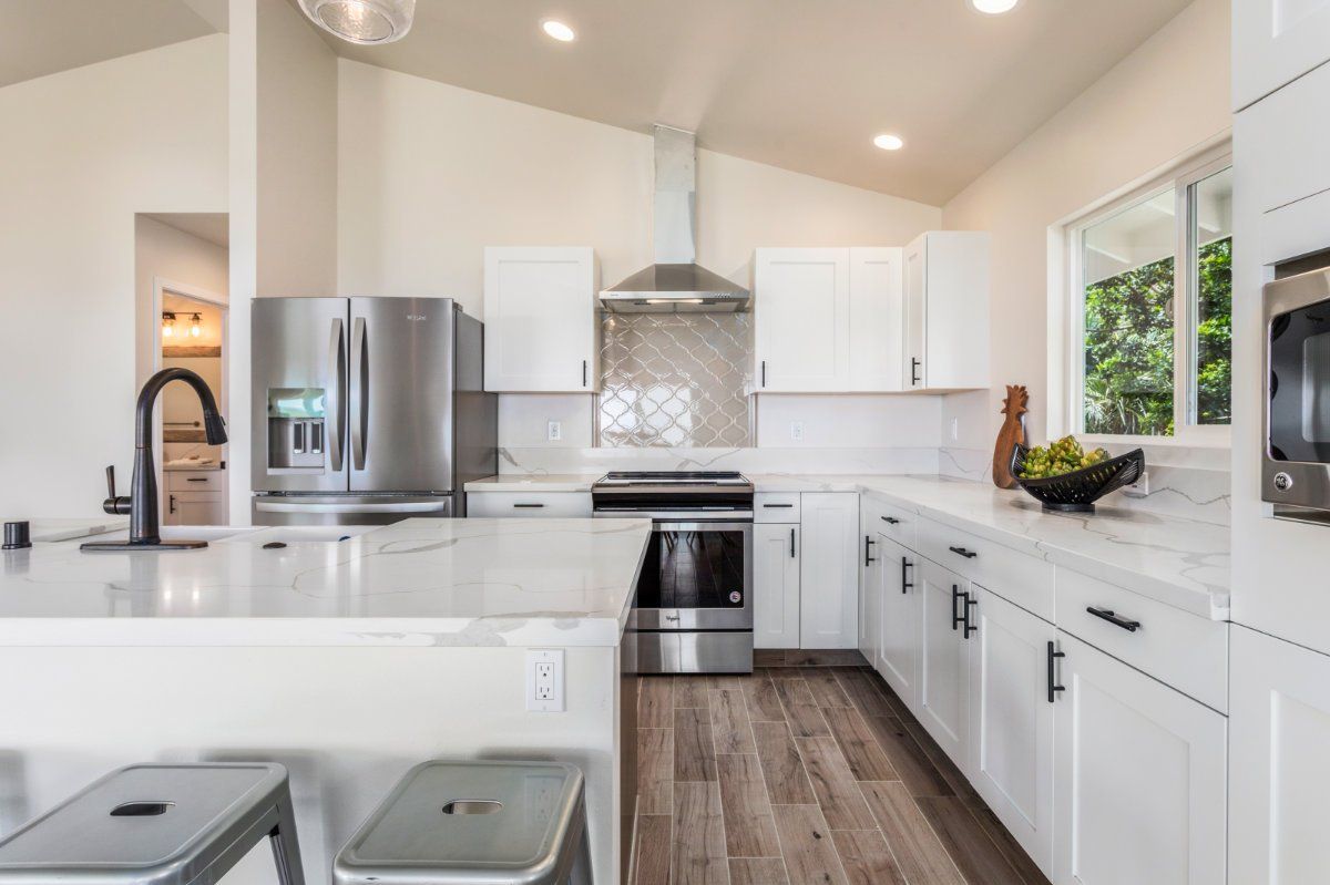 a kitchen with white cabinets and tiled backsplash. 