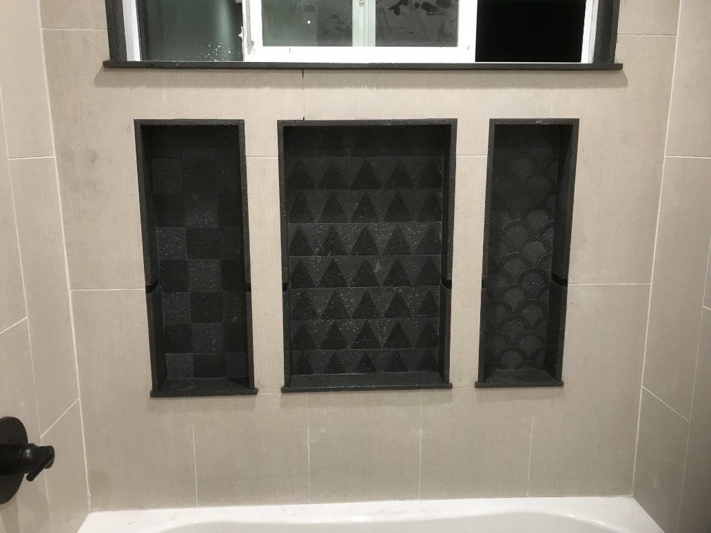 a bathroom with a tub and three tiled niches. 