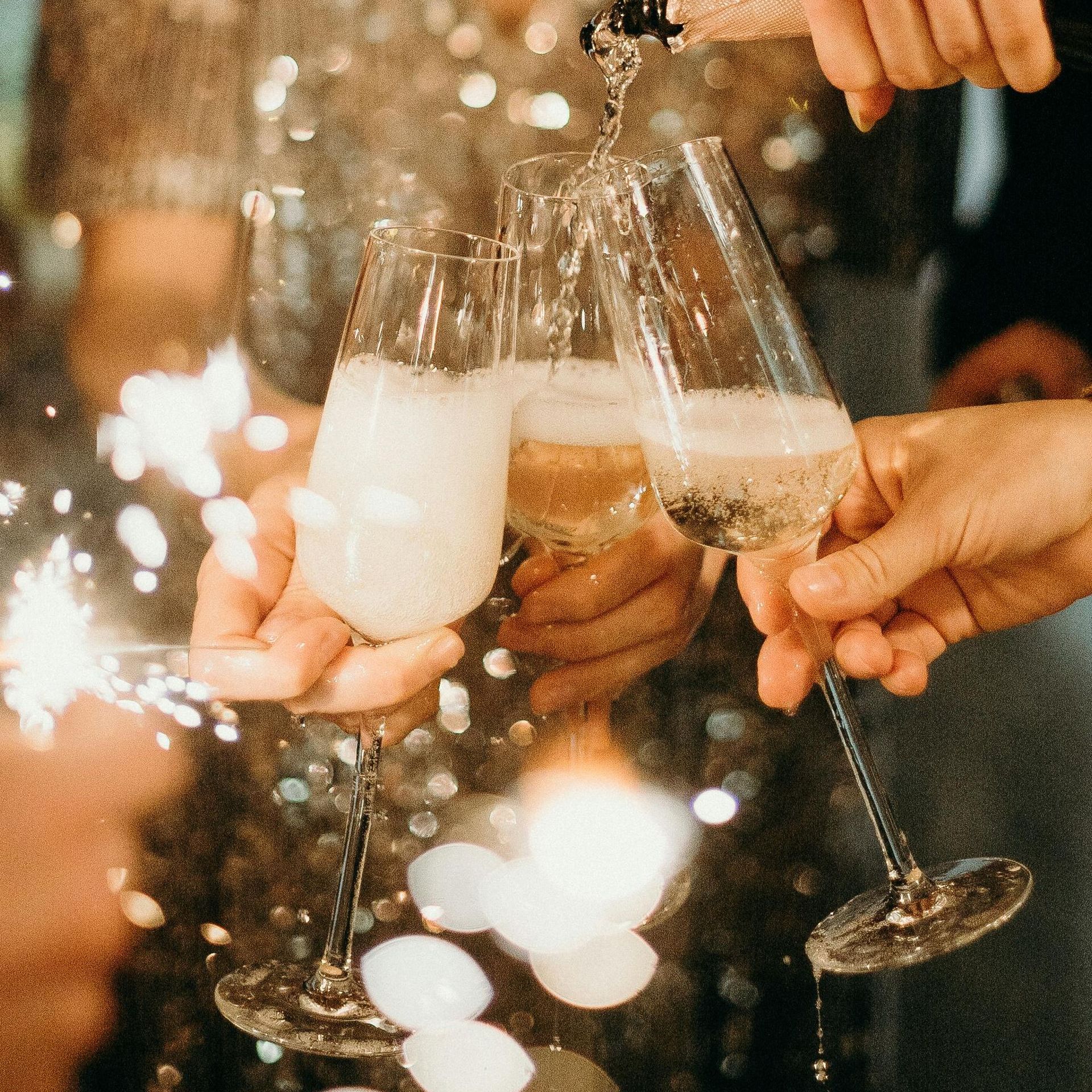 A group of people are toasting with champagne glasses and sparklers.
