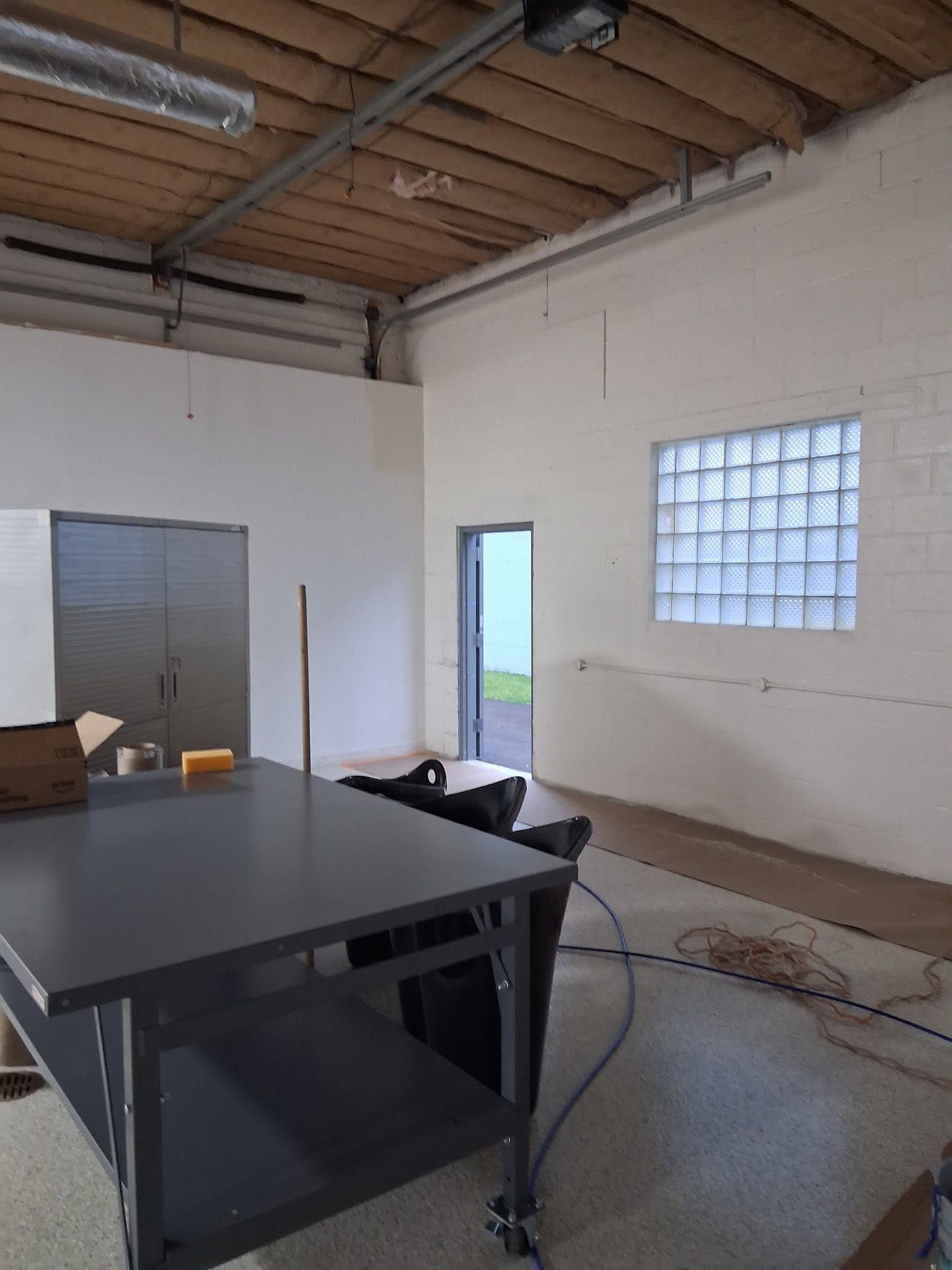 Empty industrial warehouse with a polished concrete floor and rows of overhead lights
