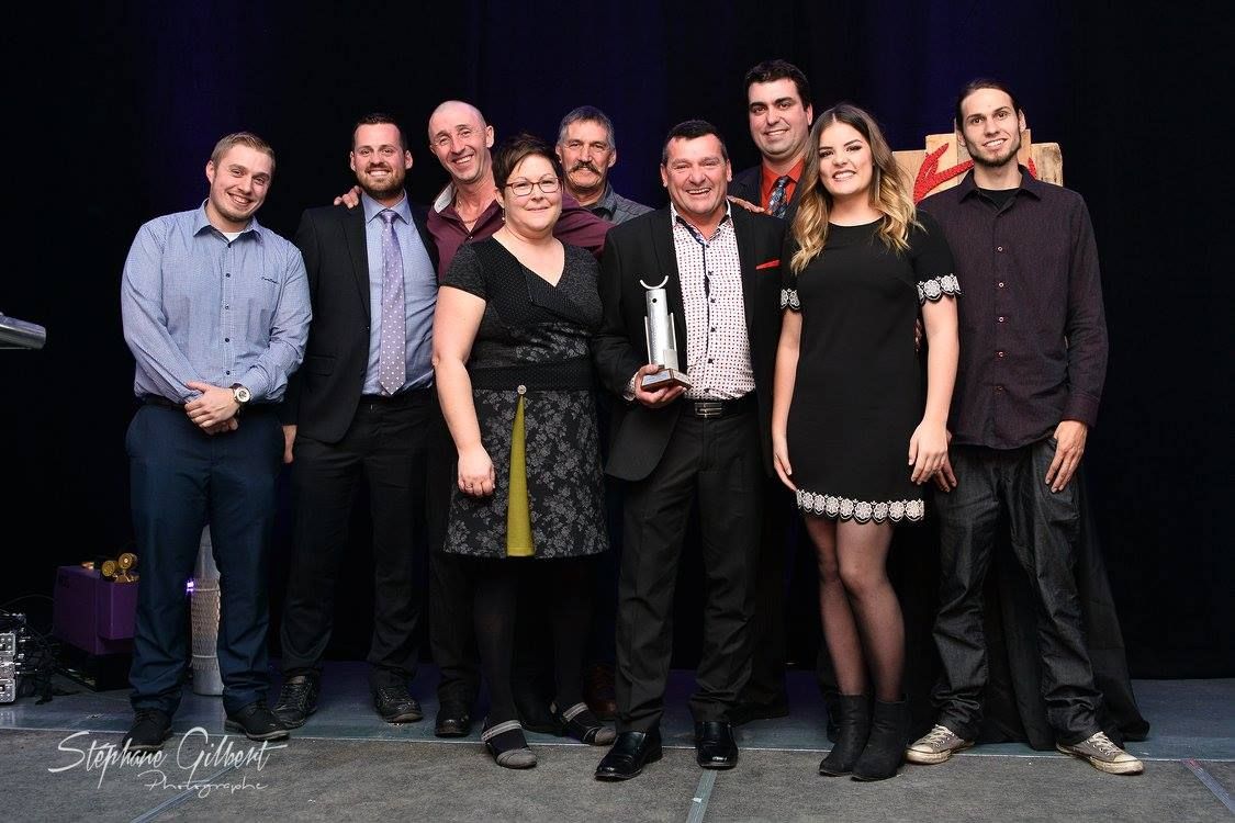 Un groupe de personnes pose pour une photo sur une scène.