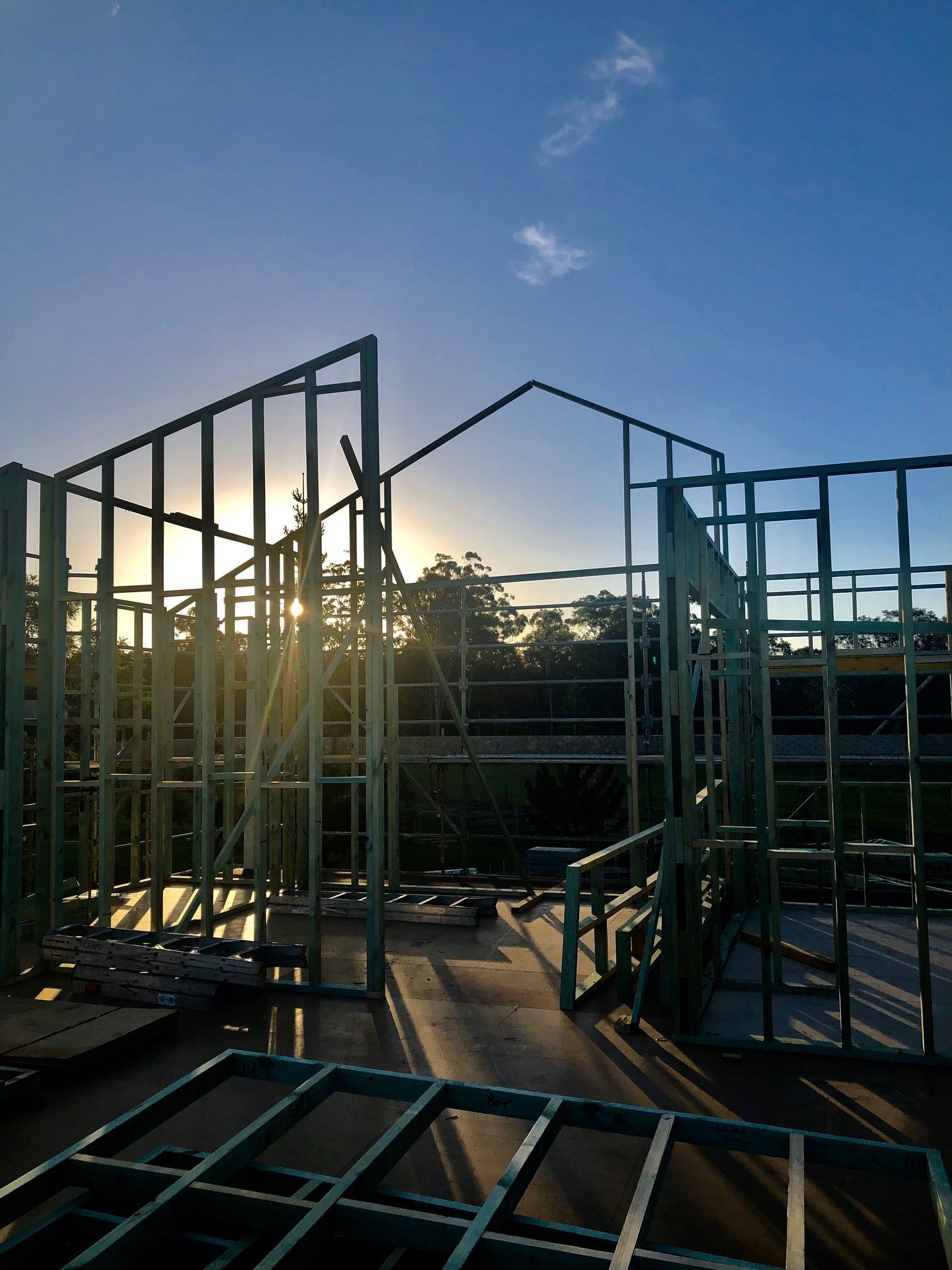 Wooden Frame Construction of a House Against a Sunset Sky — BK Building Services Pty Ltd In Taree, NSW