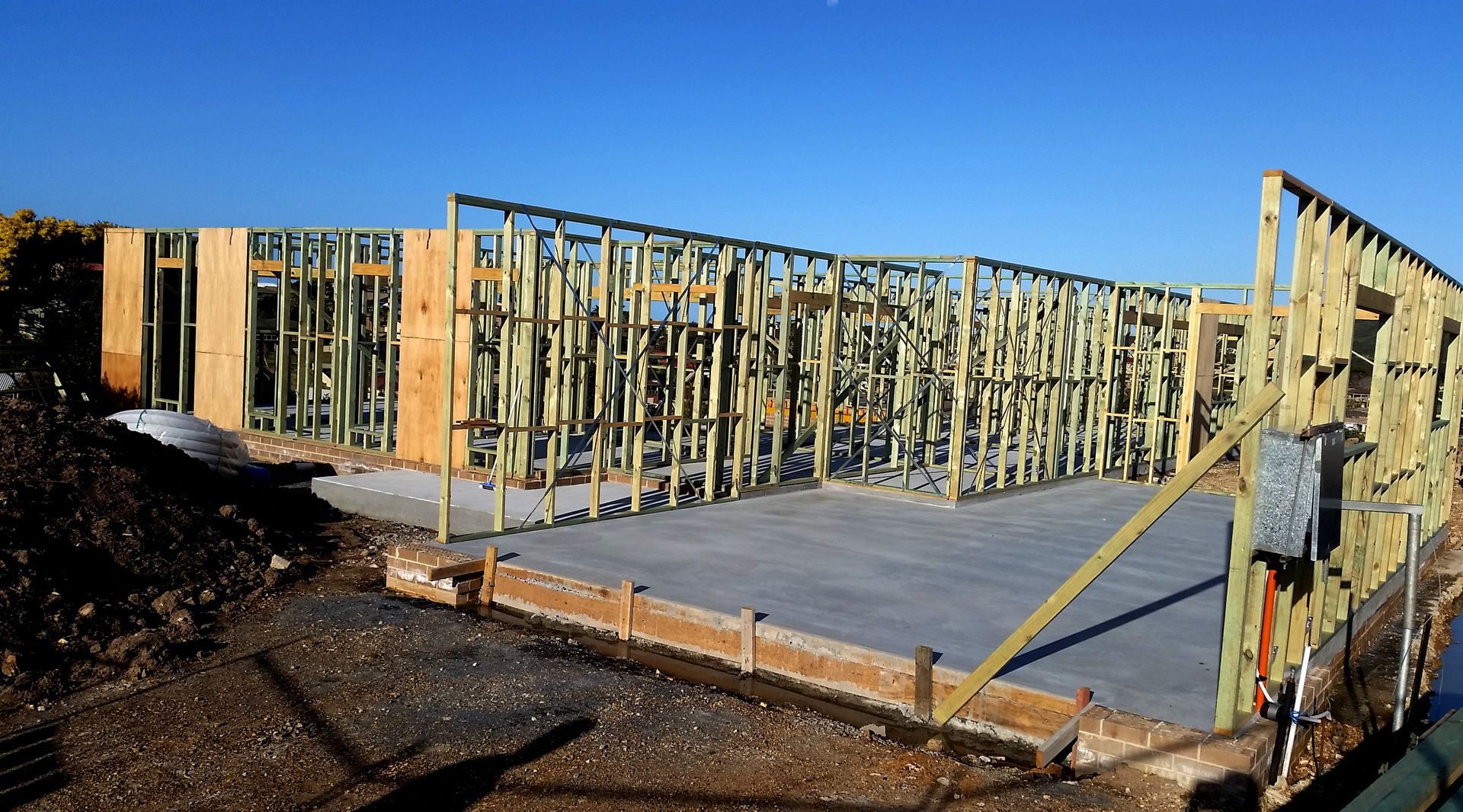 Wood Frame of a Building Under Construction on a Concrete Foundation — BK Building Services Pty Ltd In Taree, NSW