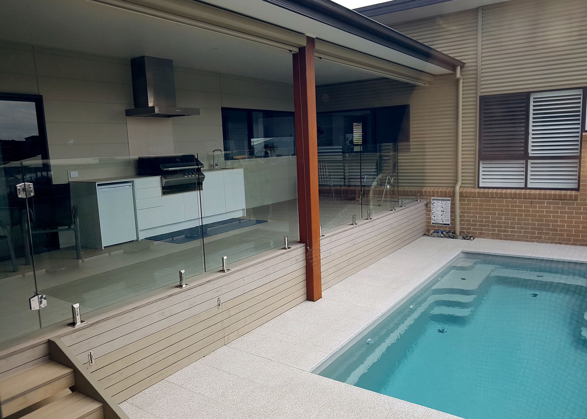 Backyard With a Pool, Outdoor Kitchen, and Glass Safety Fence — BK Building Services Pty Ltd In Taree, NSW