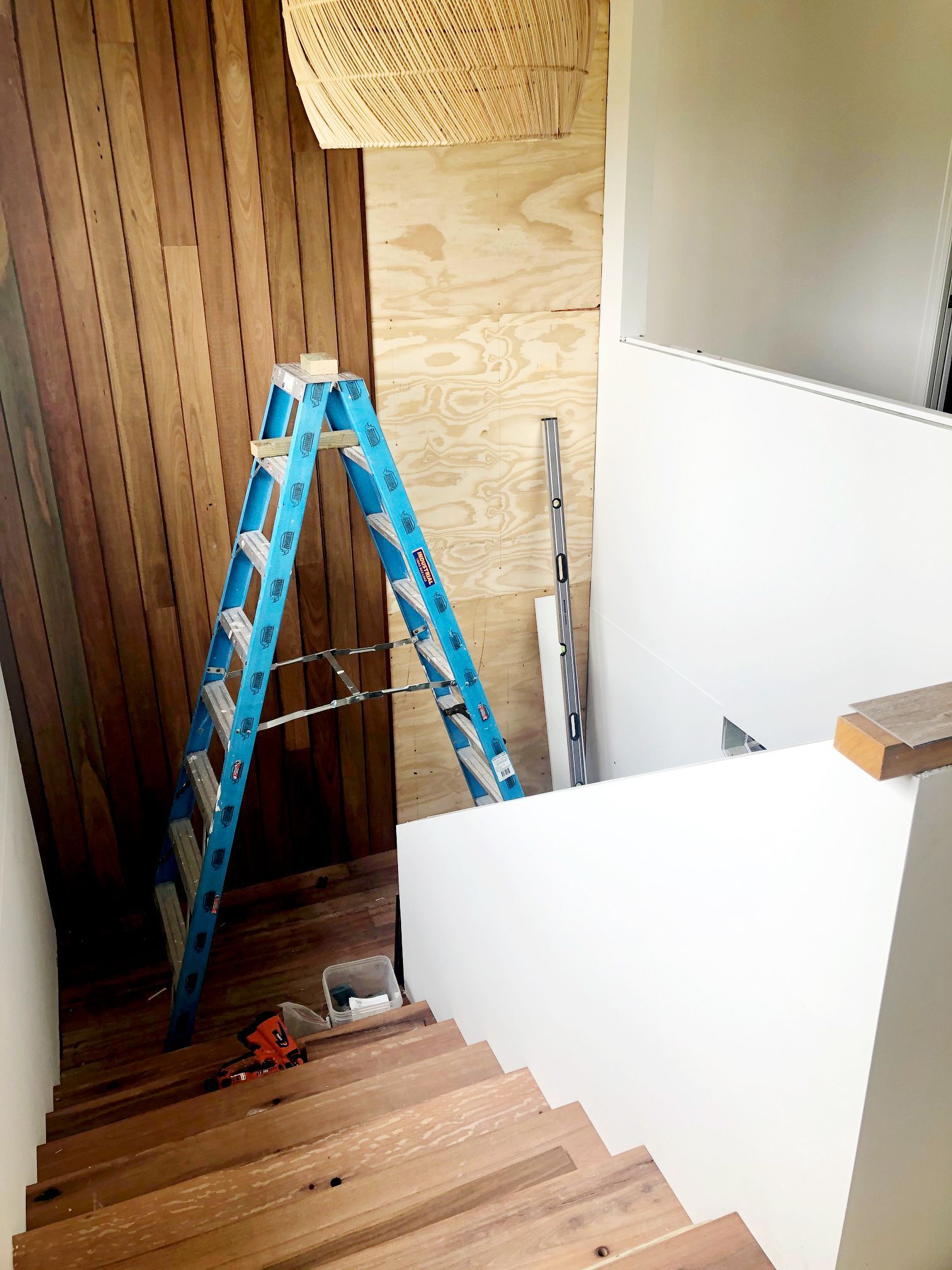Blue Ladder on Wood Stairs, Facing a Wooden Wall — BK Building Services Pty Ltd In Taree, NSW