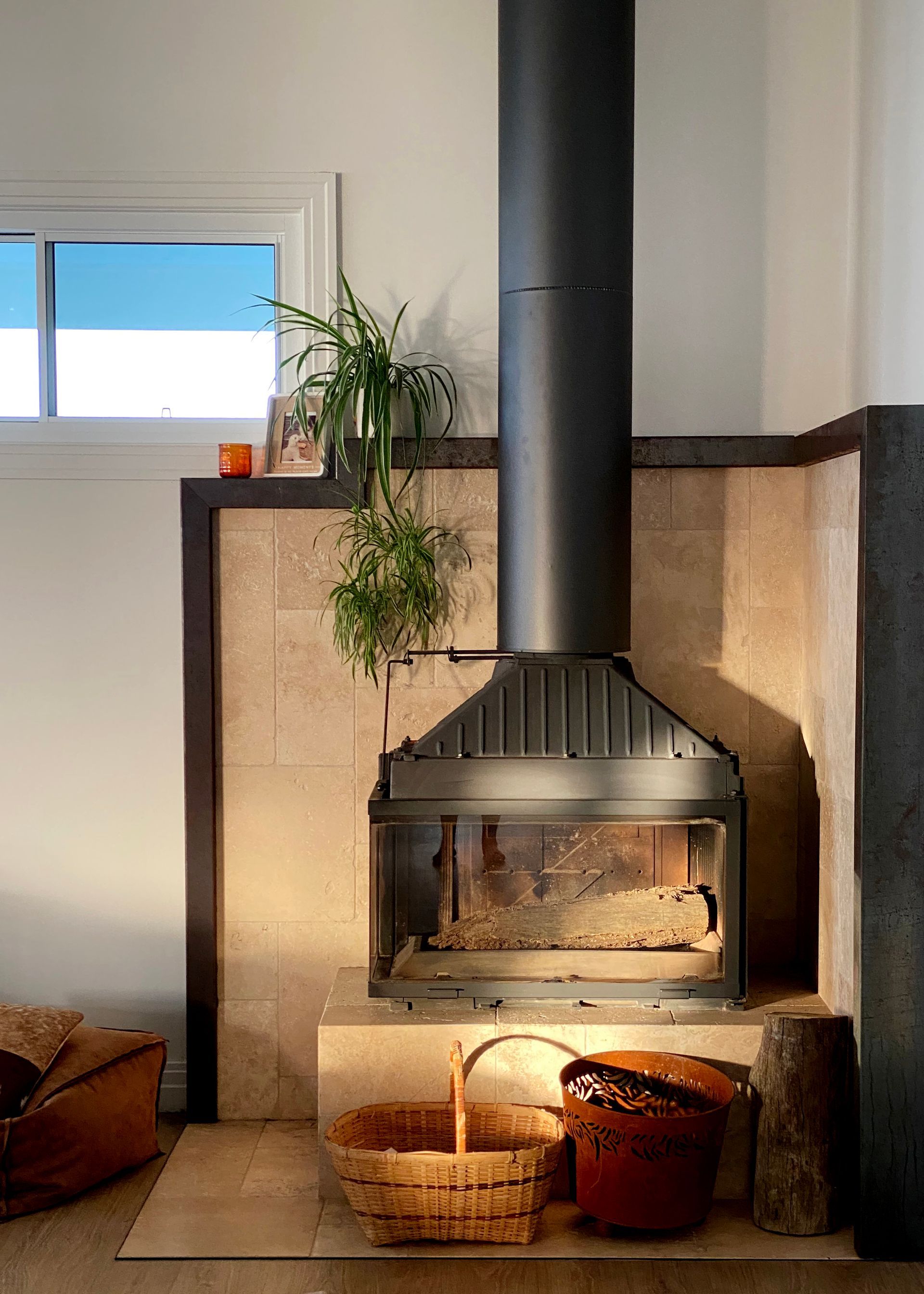 Fireplace With Black Chimney, Tile Surround, Basket, Wood, and a Small Window — BK Building Services Pty Ltd In Taree, NSW