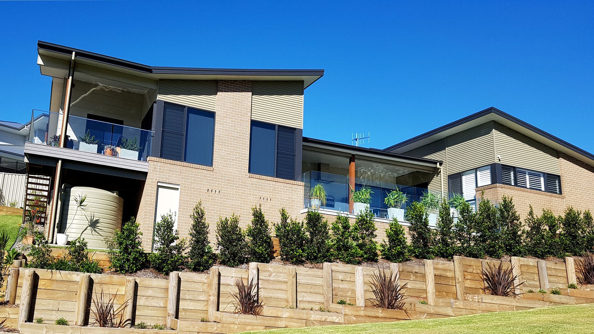 Modern House With Angled Roof, Wooden Facade, Large Windows — BK Building Services Pty Ltd In Taree, NSW