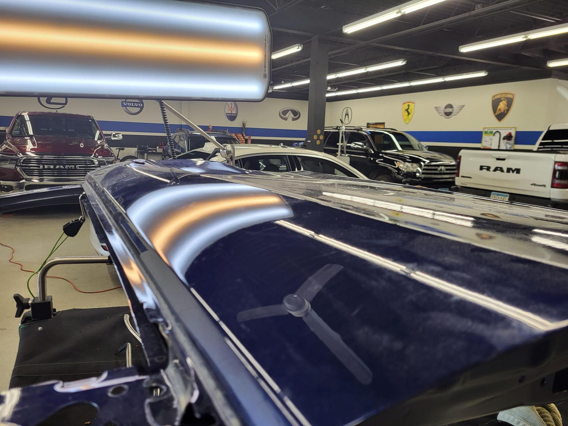 A blue ram truck is being repaired in a garage