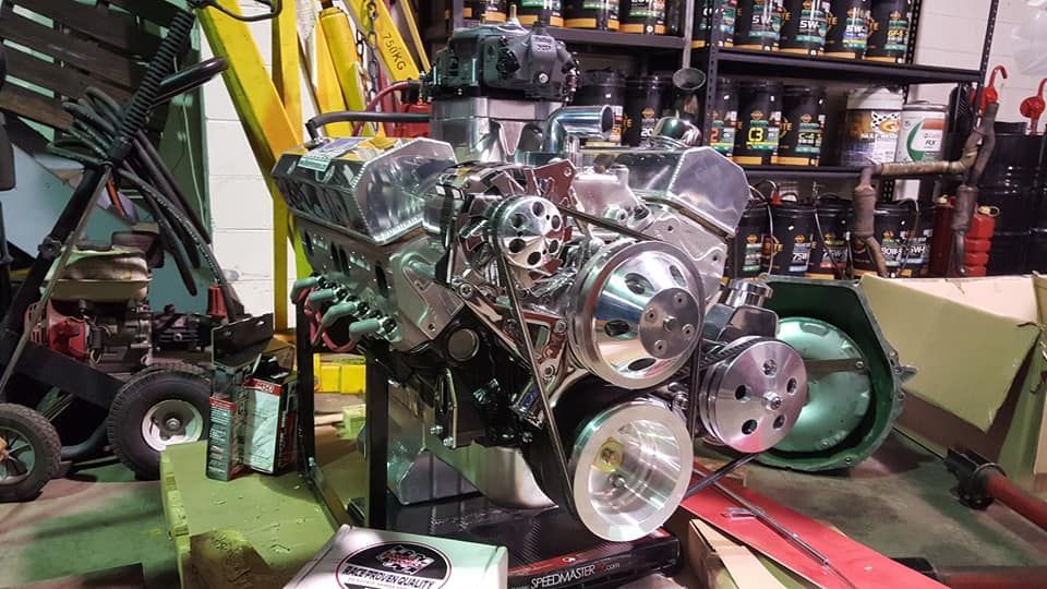 Chrome-plated car engine in a garage setting with various tools and supplies— Ottos Mufflers in Noosaville, QLD