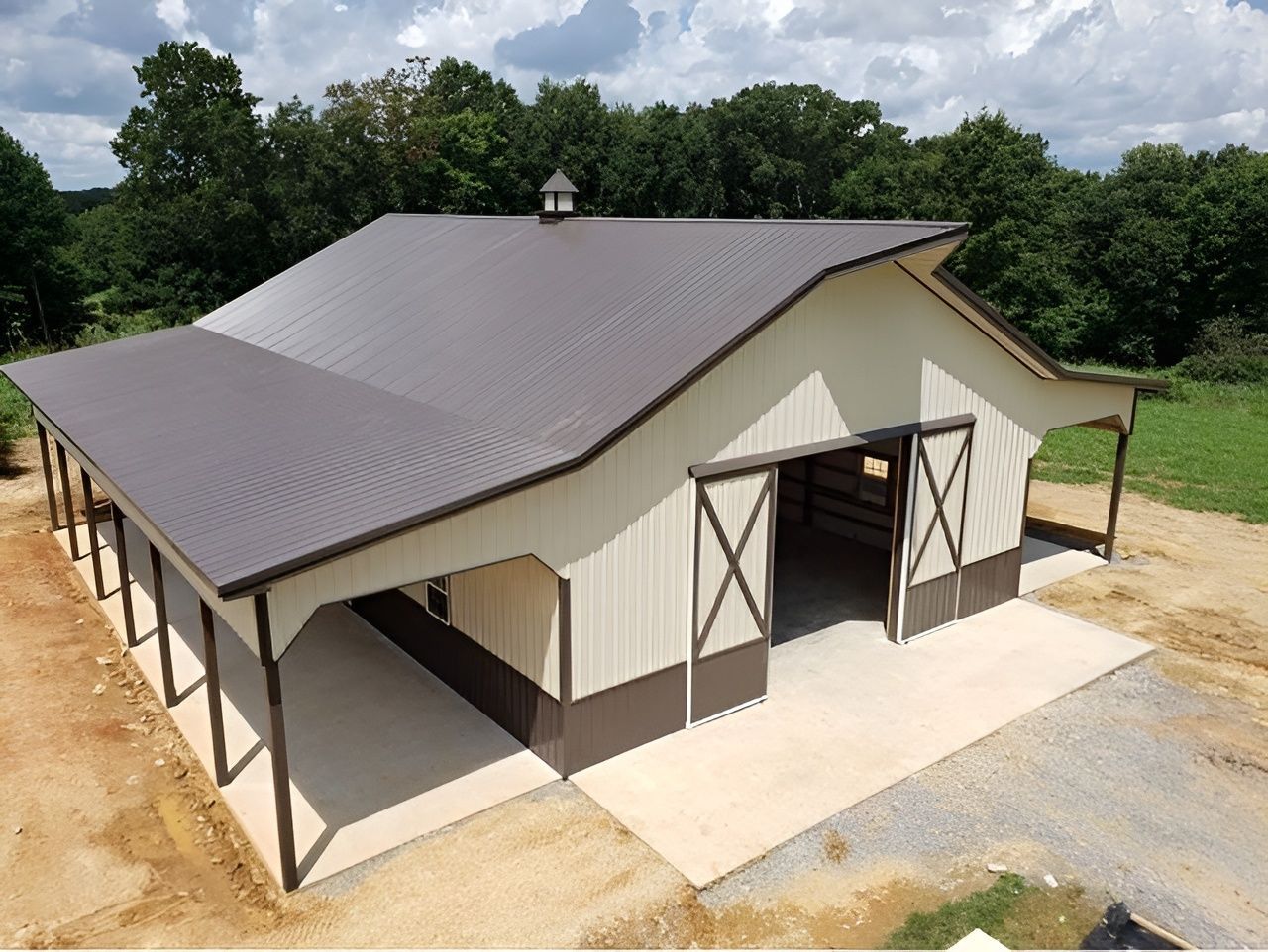 Brown and beige barn with a metal roof and open doors.