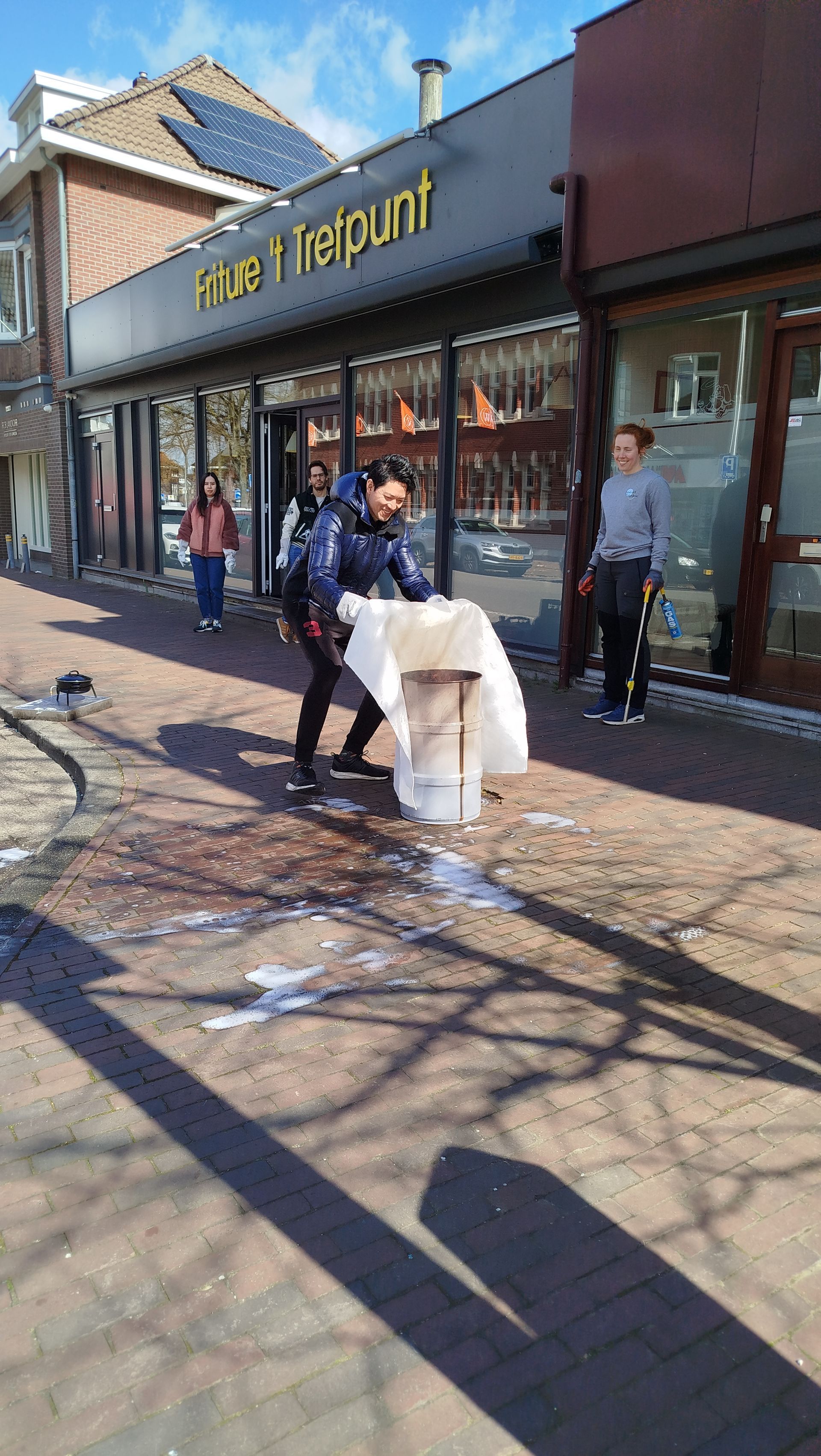 Een man blust een beginnende brand met blusdeken.