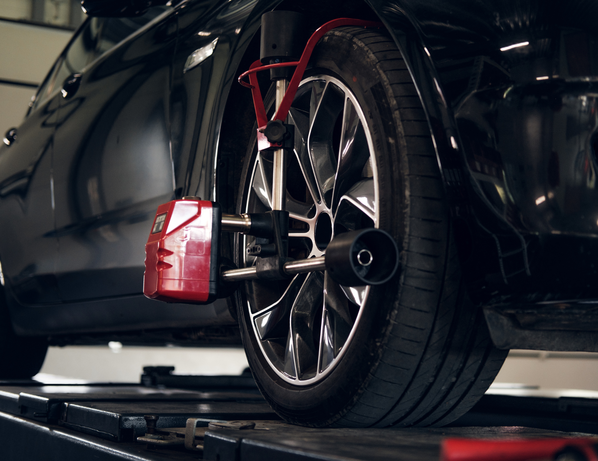 Car wheel with alignment equipment attached, on a lift.