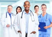 A group of doctors and nurses are posing for a picture in a hospital.