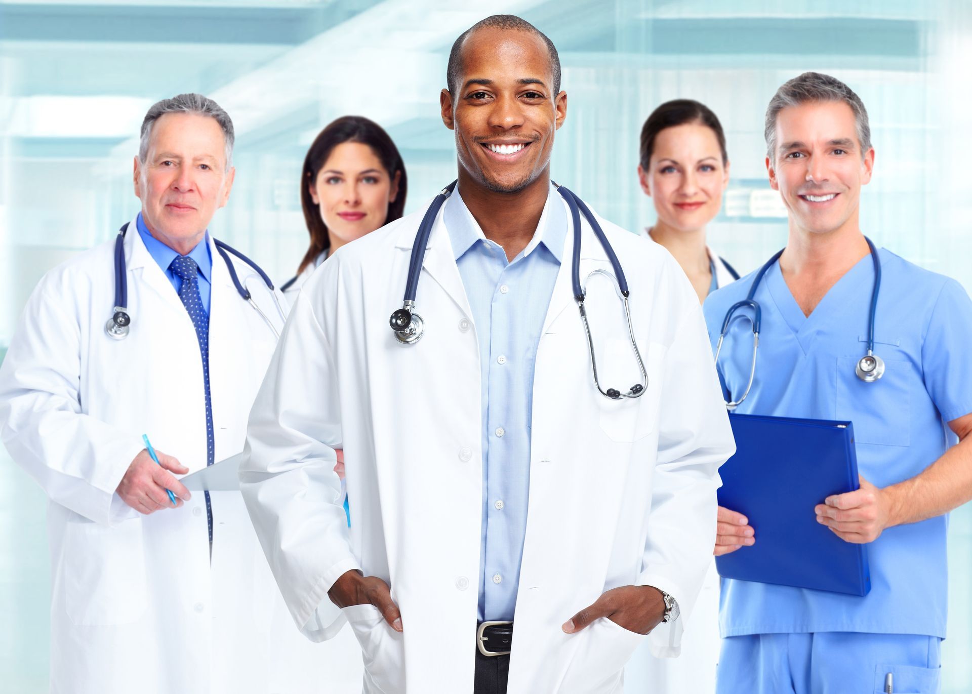 A group of doctors and nurses are posing for a picture in a hospital.