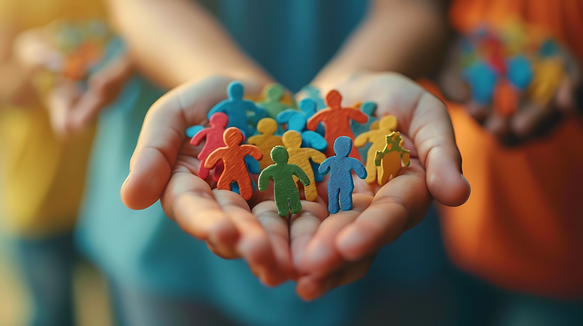 A person is holding a group of colorful people in their hands.