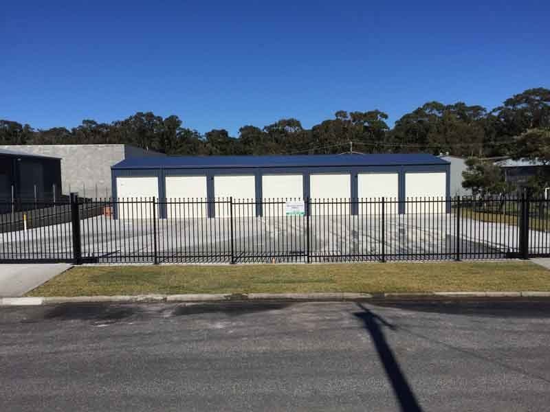 A Fence Surrounds A Building With A Blue Roof – South Kempsey NSW - Fair Dinkum Builds Macleay Valley Sheds