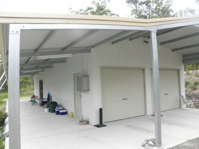 A White Building With A Covered Porch And Two Garage Doors – South Kempsey NSW - Fair Dinkum Builds Macleay Valley Sheds