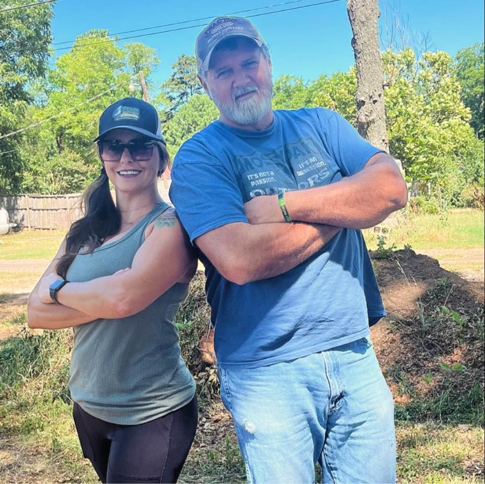A man and a woman standing next to each other with their arms crossed