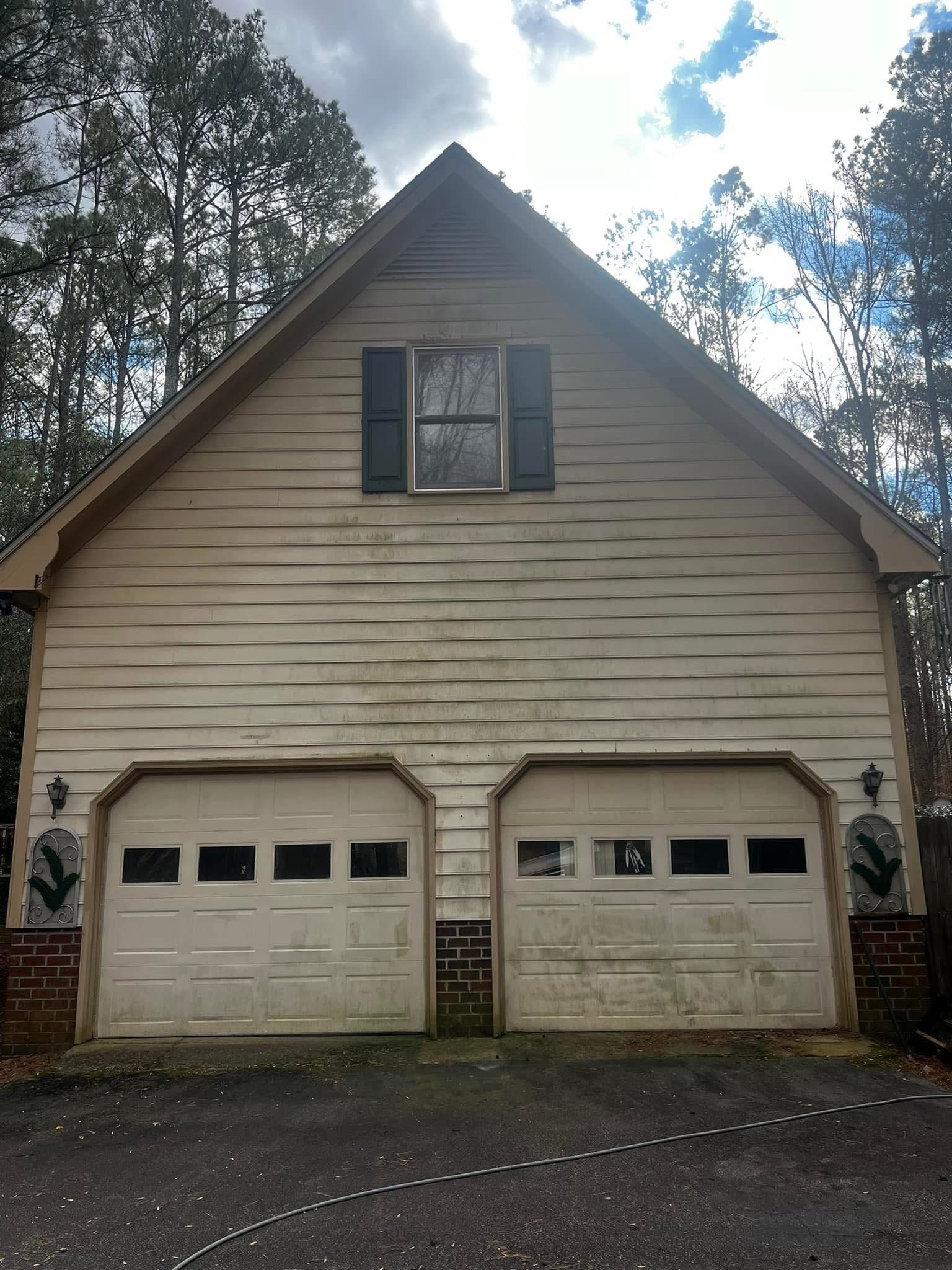 A white garage with two garage doors and a window.