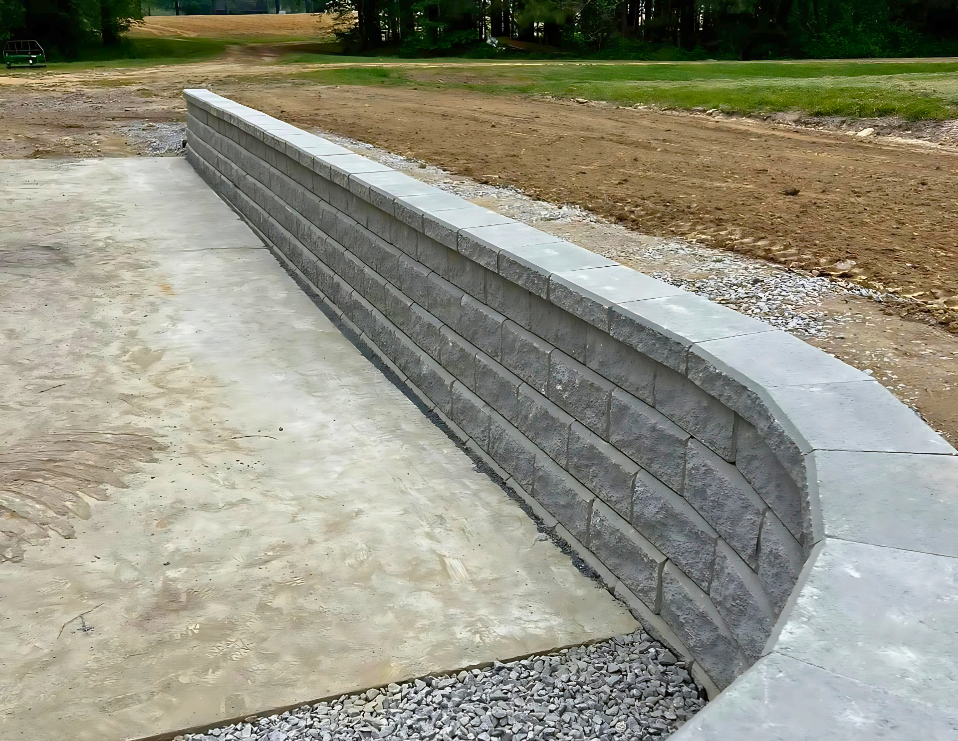 A concrete wall is being built in the middle of a dirt field.