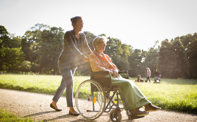Caregiver Taking Patient Out for a Stroll — Charlotte, NC — United Home Care & Health Solutions, Inc.