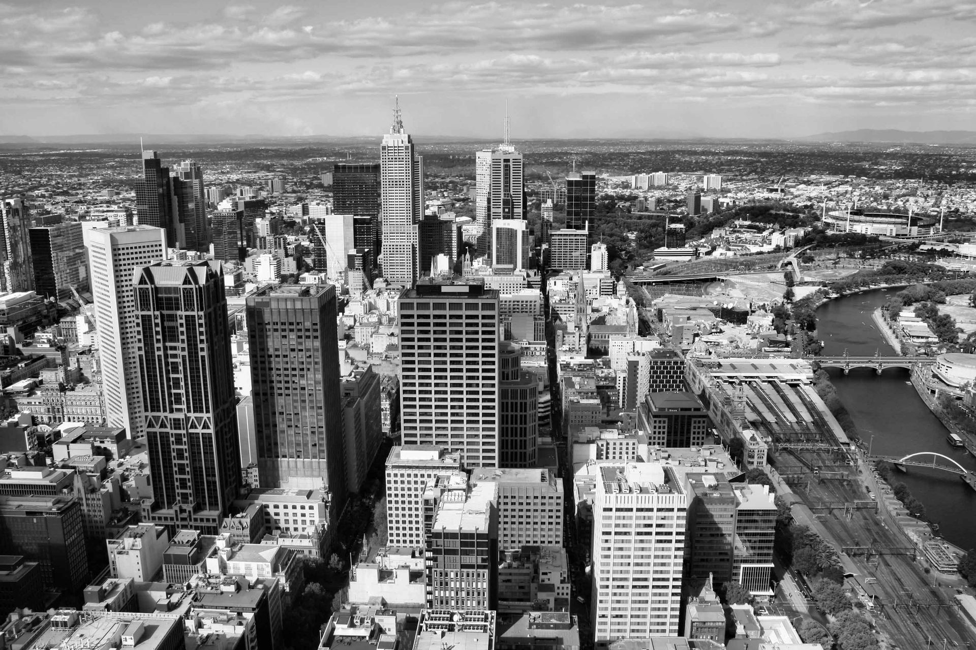 A black and white photo of a city with a river in the foreground