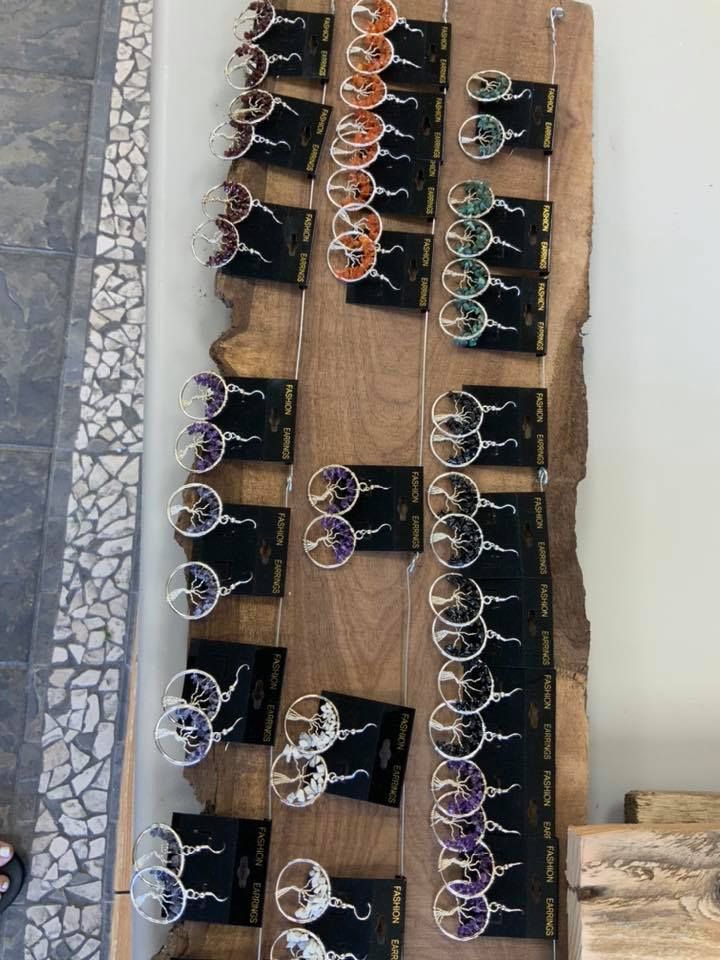 Sunglasses displayed on a wooden board. Multiple pairs of various colors: orange, green, purple, and black.