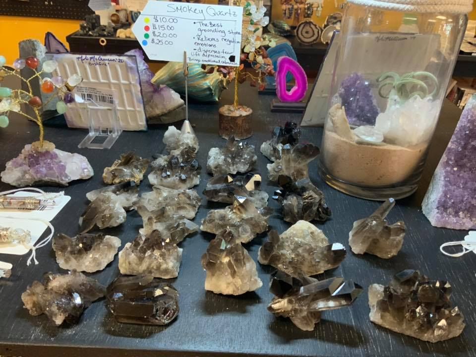 Crystal shop display with various smoky quartz clusters and other crystals in a USA shop.