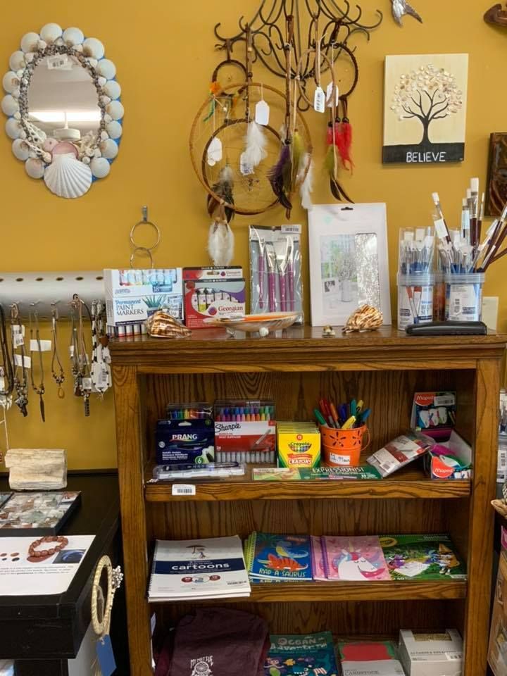 Shelves stocked with art supplies, jewelry, and dream catchers in a shop with yellow walls in a USA shop.