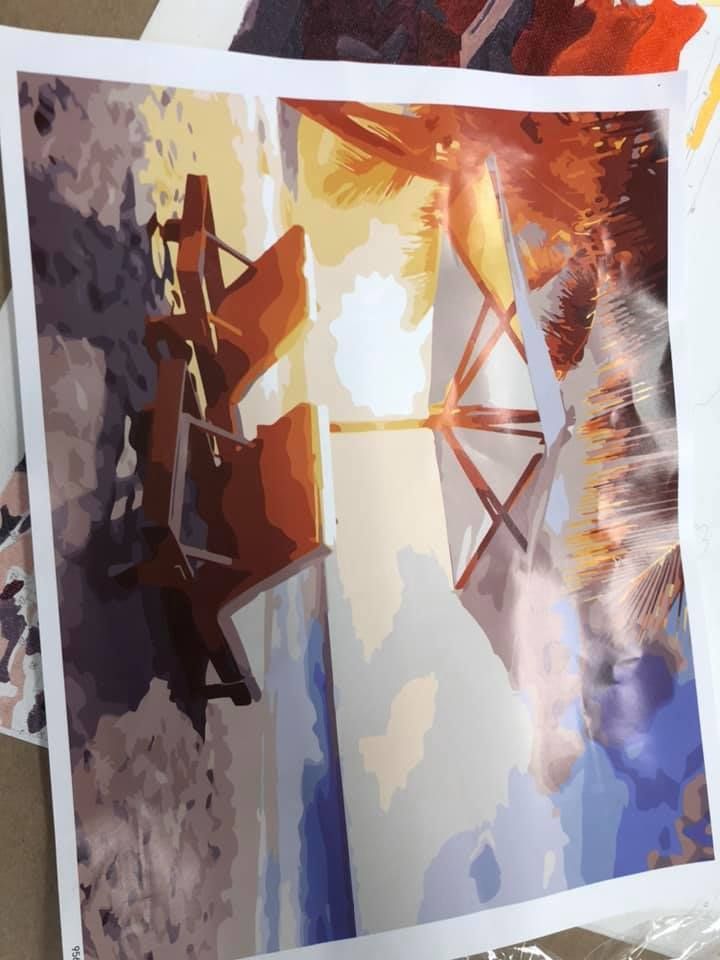 Beach scene: Windmill silhouette with warm sunlight, blue water, and brown structure in a USA shop.