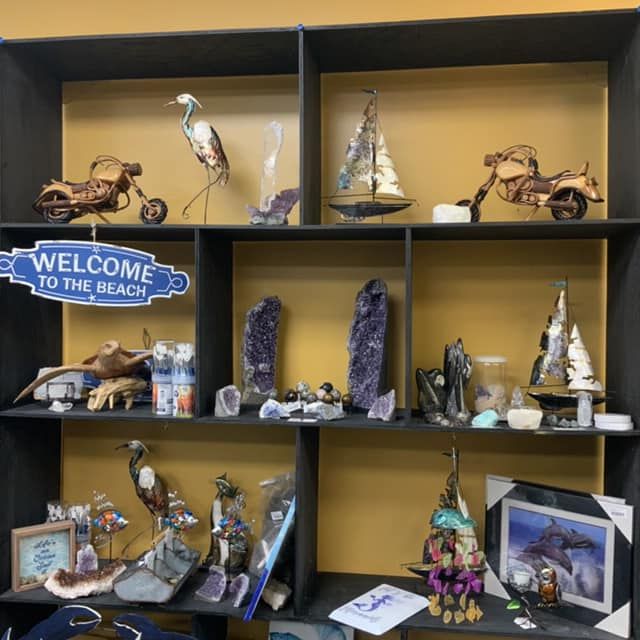 Shelf display of coastal decor: sculptures, crystals, and a 