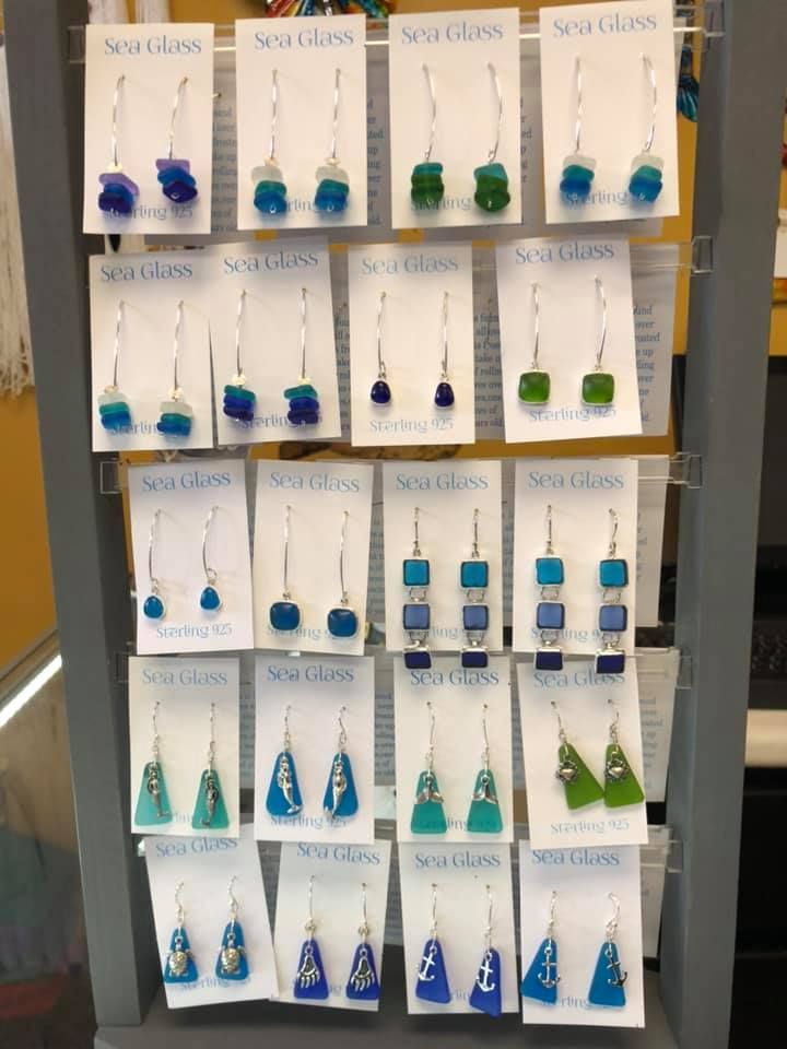 Earring display: Sea Glass earrings in shades of blue and green, hanging on white cards in a USA shop.