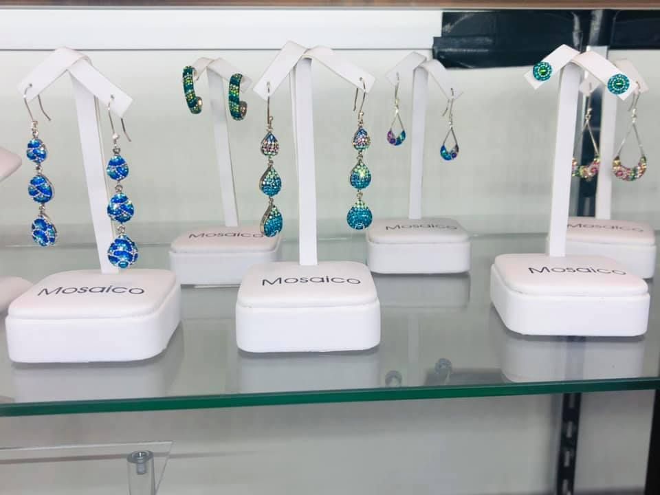 Earrings on display stands in a store, featuring blue and silver designs.