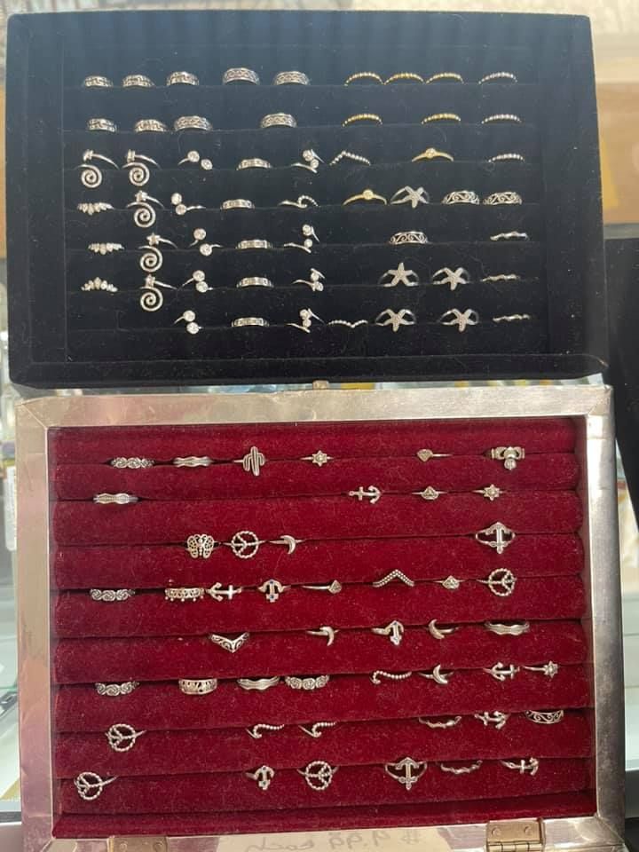 Jewelry display case; rings in velvet-lined trays; black and red background; various ring designs.