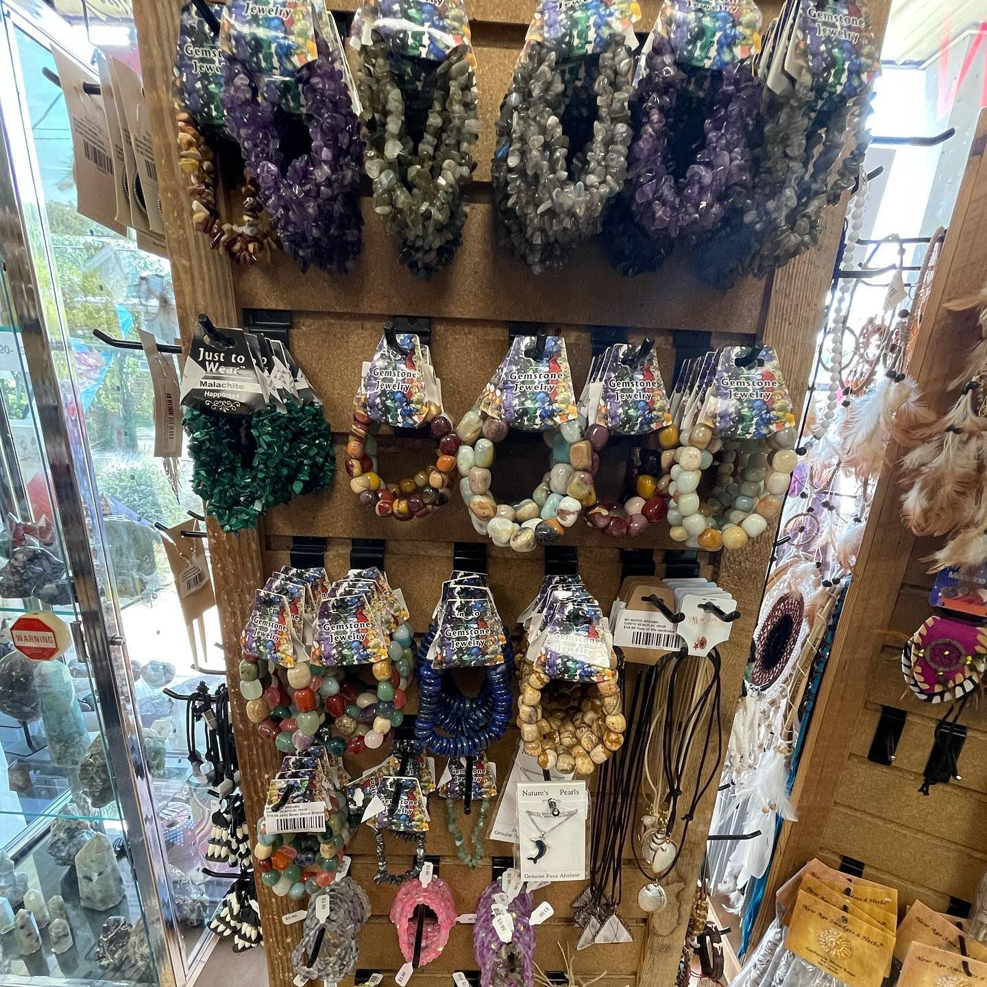 Jewelry display with beaded bracelets of various colors and styles, showcased in a store.