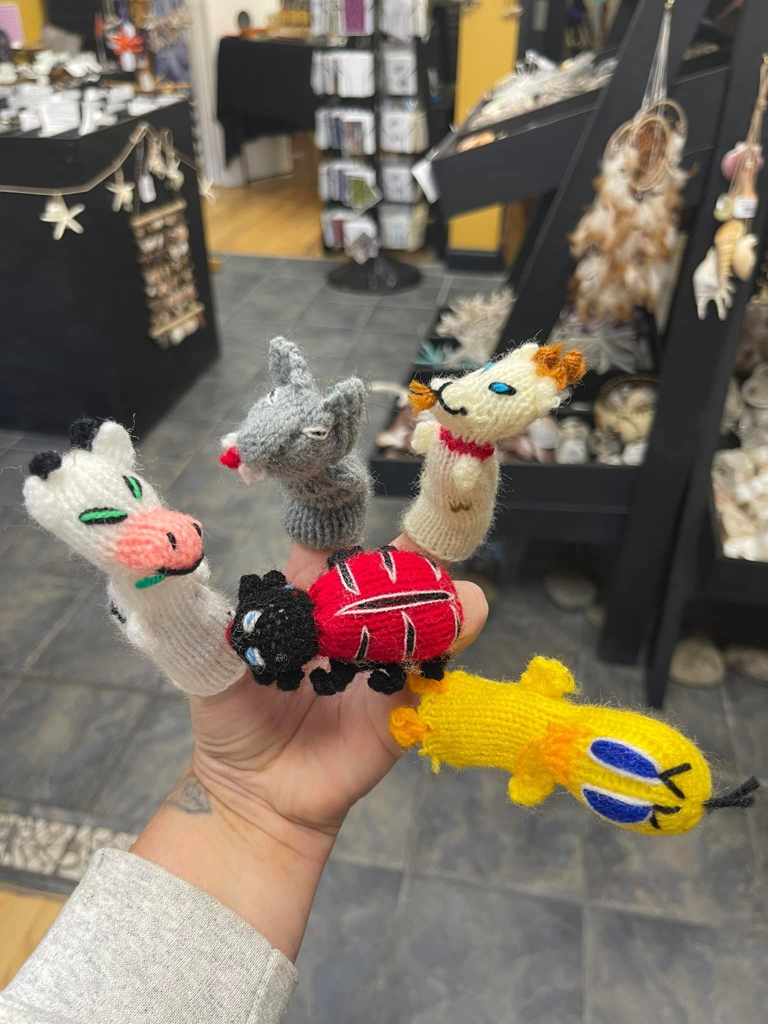Hand holding five beaded finger puppets: cow, mouse, dog, ladybug, and chick.