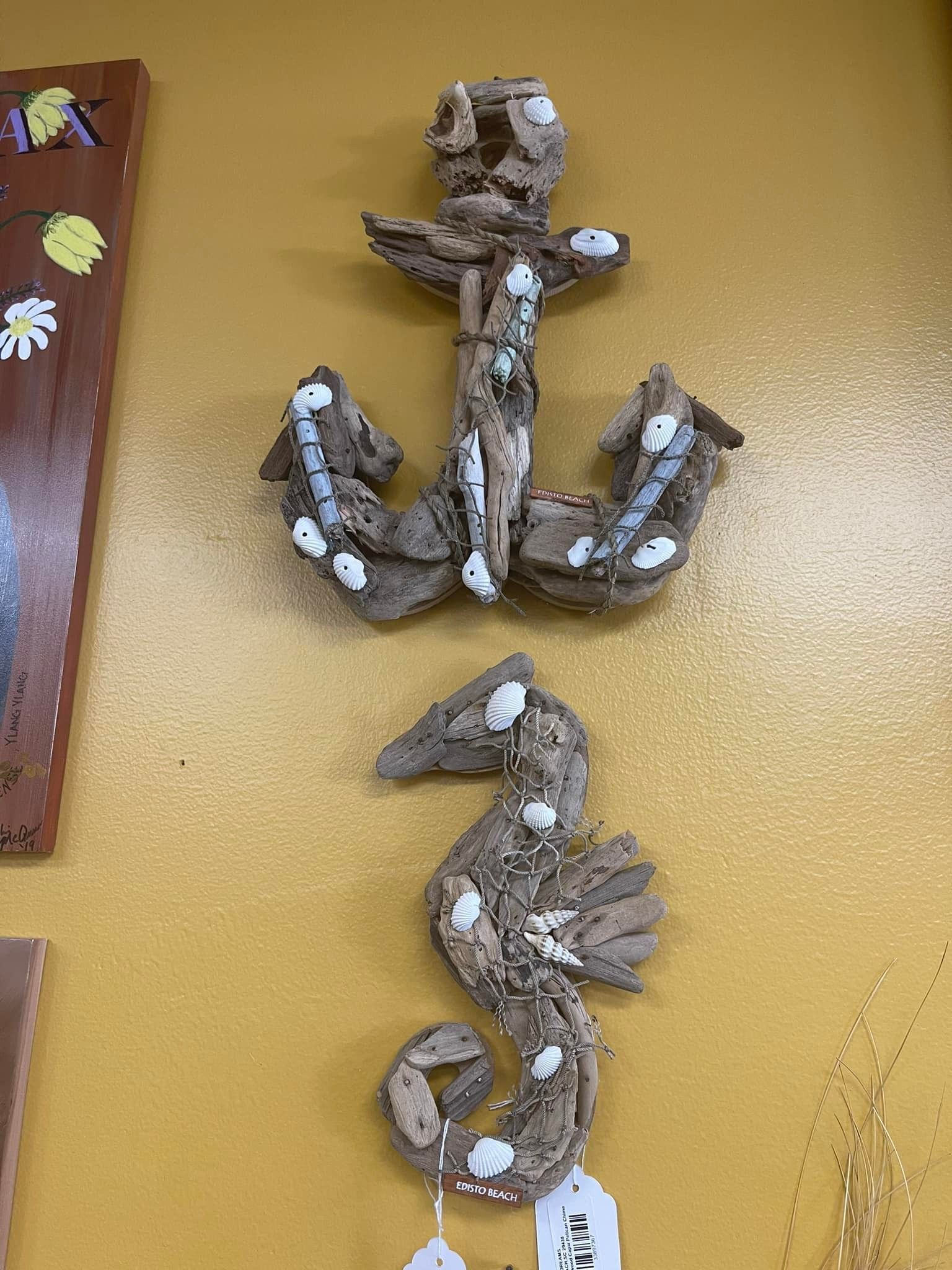 Driftwood anchor and seahorse wall art on a yellow wall, white accents.