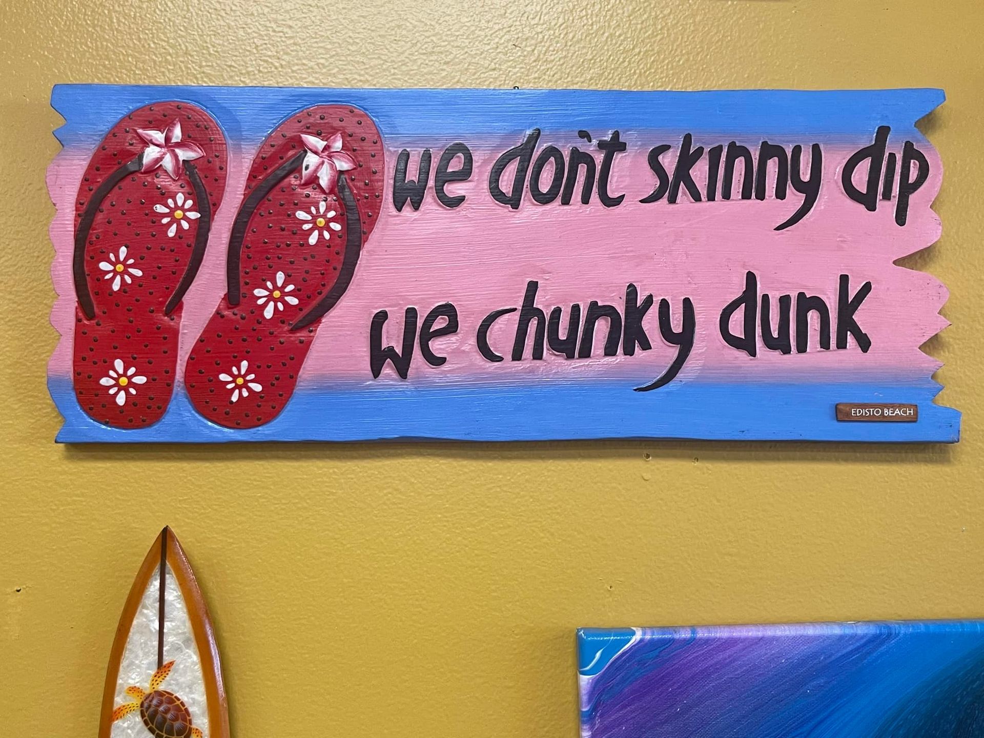 Wooden sign with flip-flops and the words: 